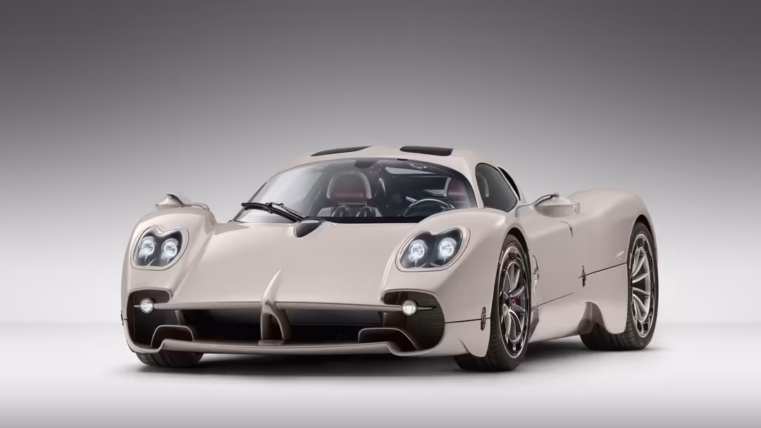 Cream-colored Pagani Utopia hypercar with distinctive dual headlights and open cockpit displayed against neutral background