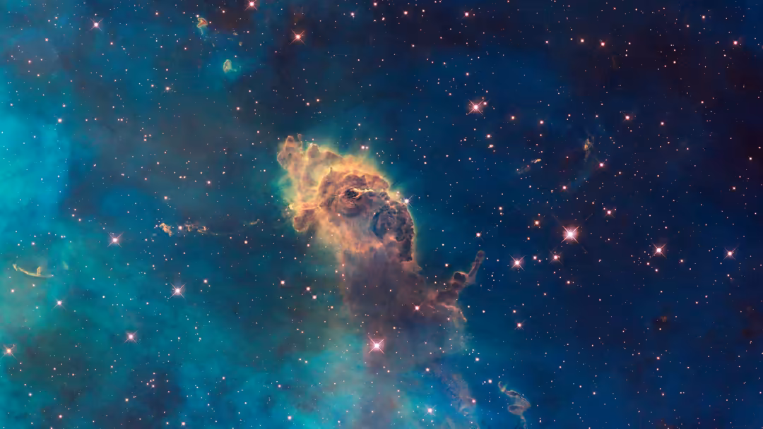 Carina Nebula with glowing golden gas clouds and scattered stars against deep teal and blue cosmic space backdrop