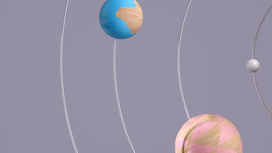 Minimalist 3D render of colorful planets suspended by thin wires against a soft lavender background with textured surfaces.