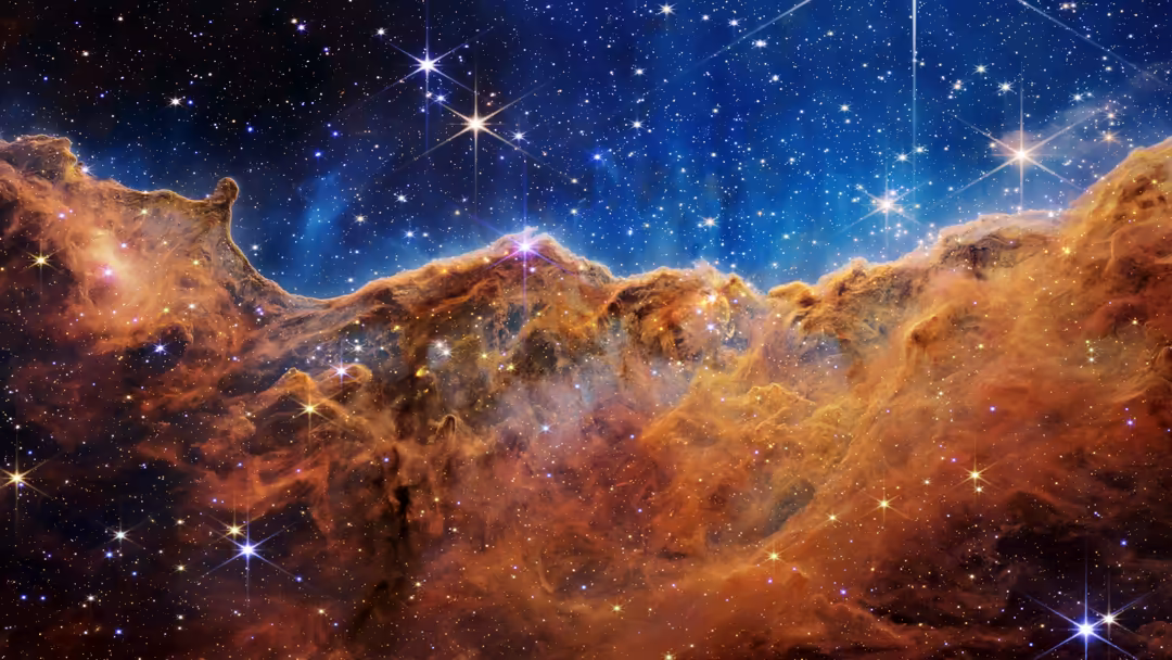 Dramatic cosmic landscape showcasing the Carina Nebula with golden dust clouds and brilliant stars scattered across deep blue