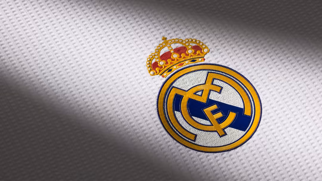 Real Madrid CF embroidered crest with golden crown and blue shield on white textured background