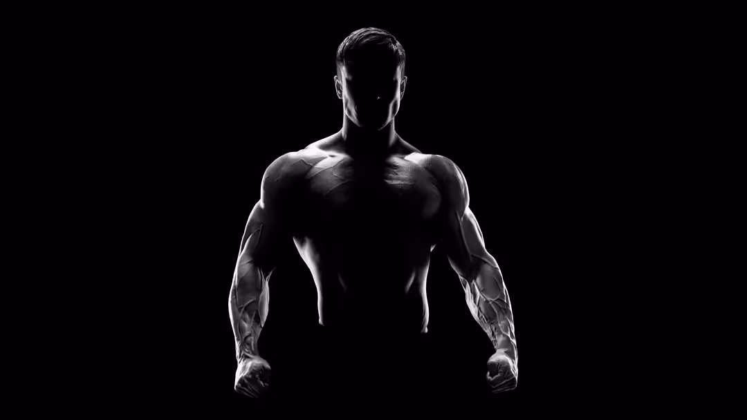 Silhouette of a muscular bodybuilder posing against a black background, showcasing defined physique and athletic strength