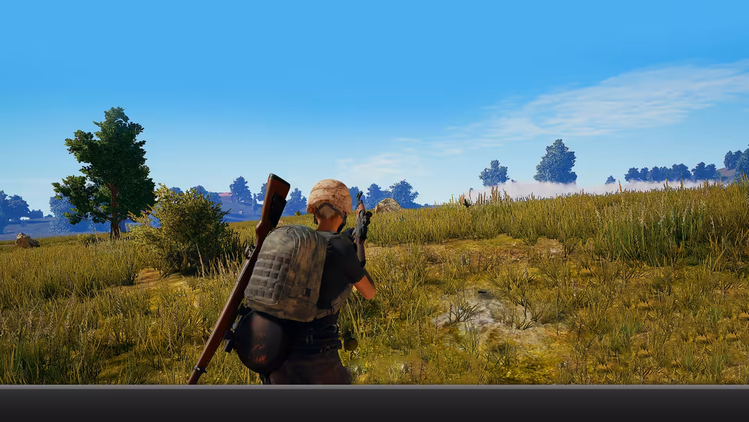 Player character carrying rifle standing in vast golden grassfield with blue sky and distant trees in tactical survival game