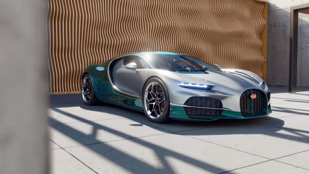 Sleek Bugatti Tourbillon hypercar with teal and silver exterior parked in modern showroom with wavy wooden backdrop and drama