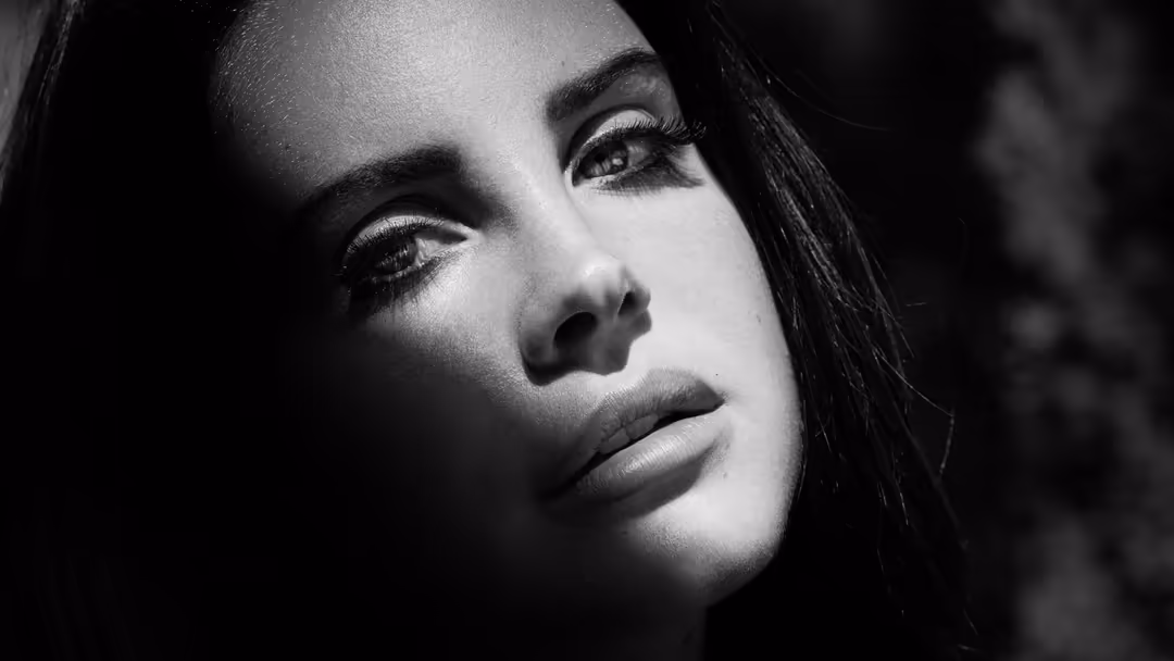 Black and white cinematic portrait of a woman with dramatic lighting, intense gaze, and vintage-inspired makeup with sharp ey