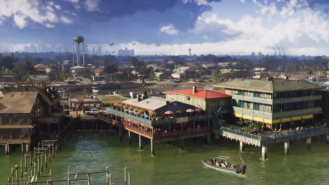 Vibrant waterfront district with colorful buildings, boats, and distant city skyline under blue sky with white clouds