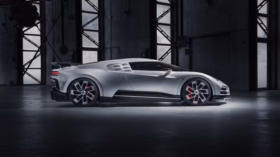 Silver Bugatti Centodieci hypercar displayed in a modern industrial garage with dark steel beams and dramatic lighting from w