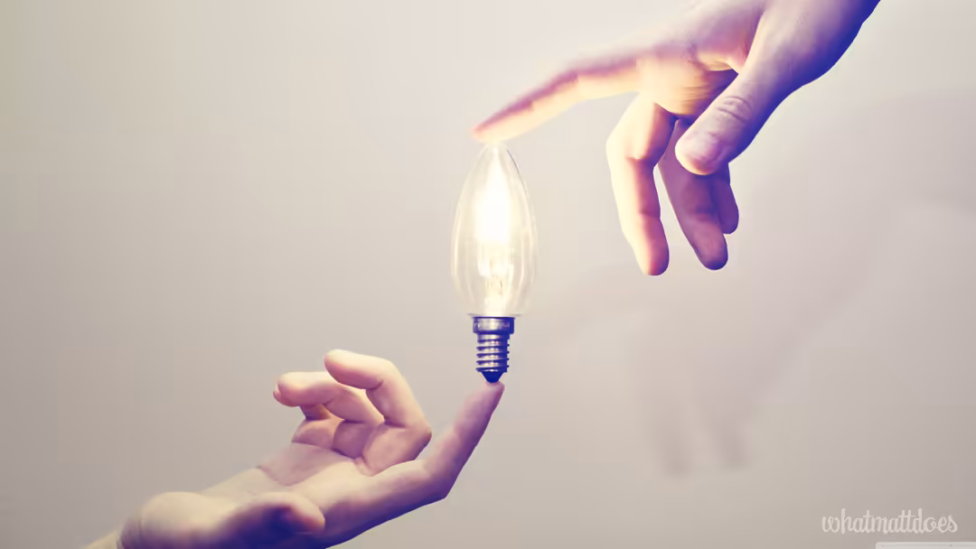 Two hands exchanging a glowing lightbulb against a soft beige background, symbolizing idea transfer and inspiration with warm