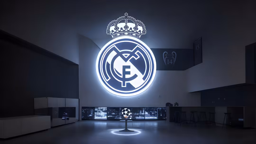 Glowing neon Real Madrid CF logo with crown on dark wall in modern stadium setting with sports displays