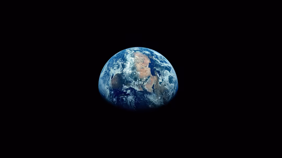 Planet Earth suspended in black space showing blue oceans, white clouds, and brown continents in detailed orbital perspective