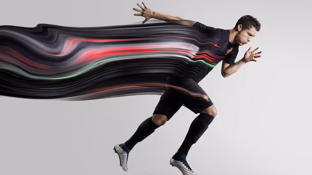 athlete in black sportswear leaps horizontally against gray background with red and green light streaks trailing behind in…