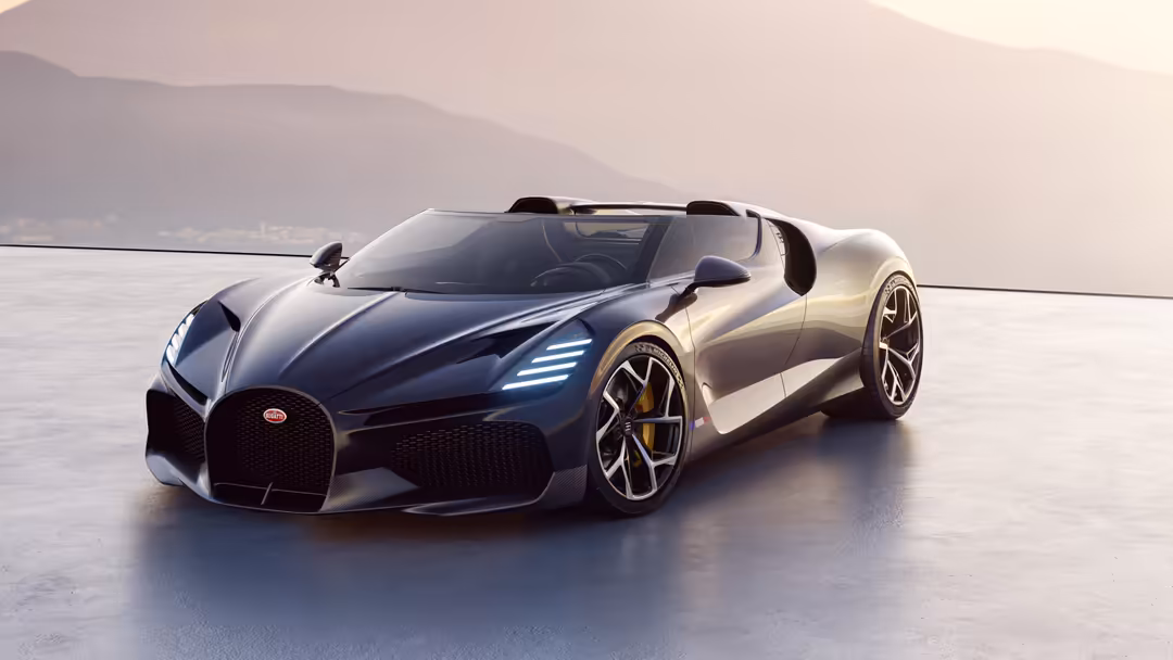 Black and silver Bugatti W16 Mistral convertible sports car parked on a reflective surface with misty mountains in background