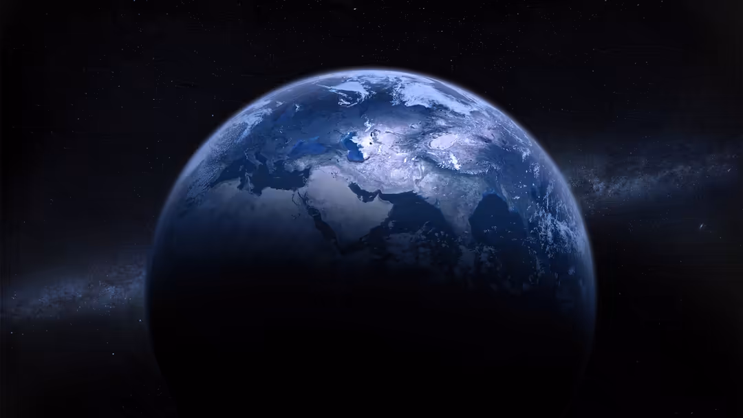 Planet Earth illuminated against a starry cosmic background, showing continents and clouds with deep space darkness surroundi