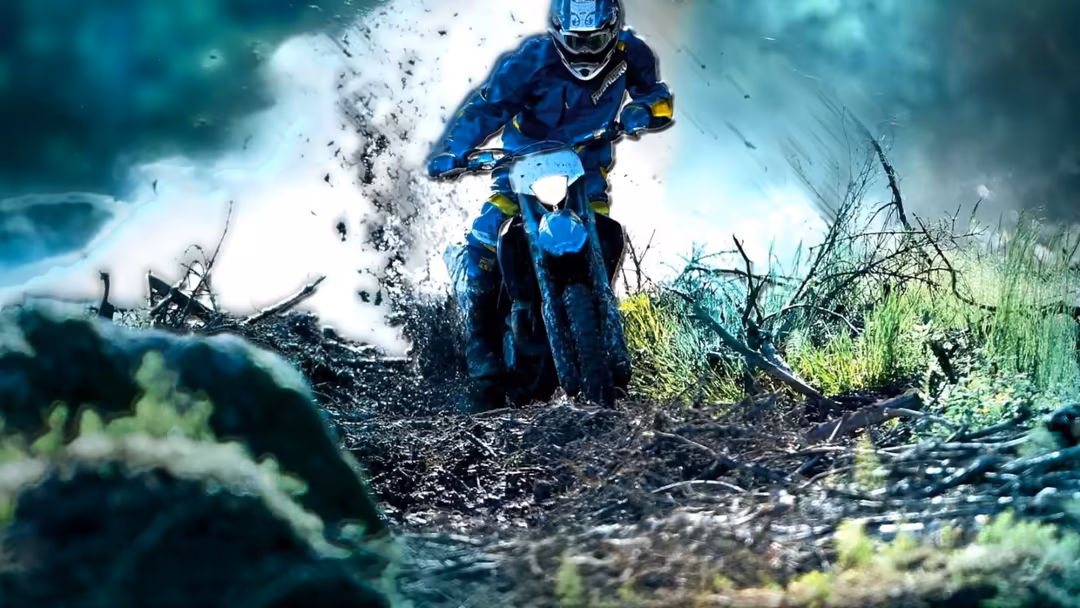 Motocross rider in blue gear on dirt bike creating massive water and mud splash during off-road racing action