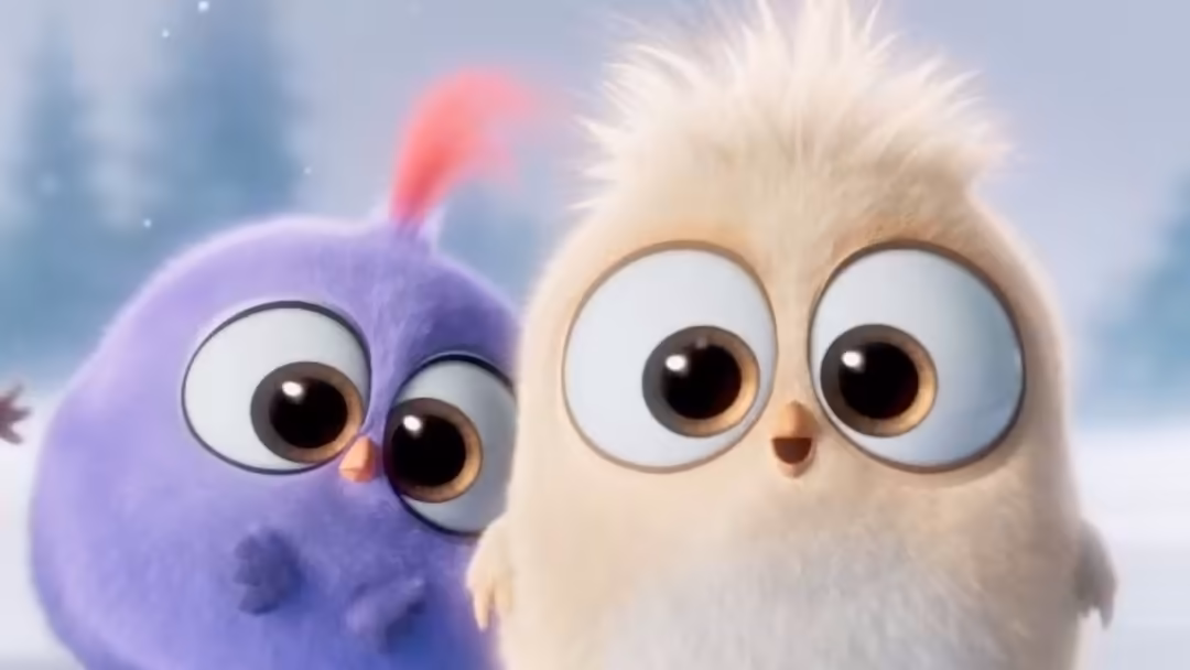 Two adorable fluffy animated birds with large expressive eyes, one purple and one white, against a soft snowy background with