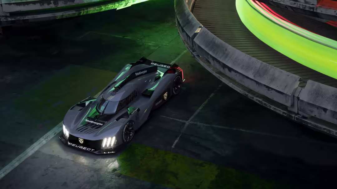 Black Peugeot 9X8 race car with neon green accents and glowing headlights on a race track surrounded by tire barriers