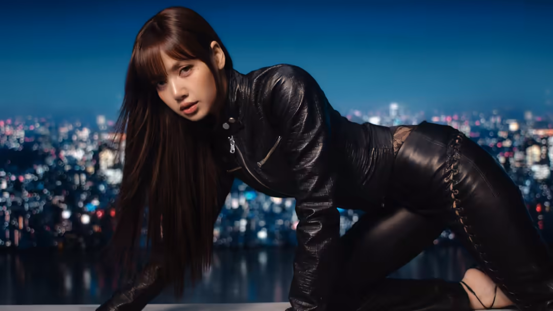 Lisa in black leather jacket leaning forward against blurred neon cityscape with teal and pink bokeh lights at night