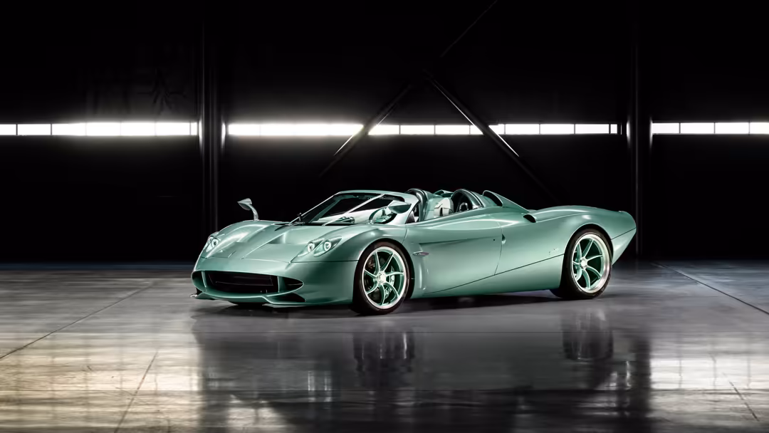 Mint green Pagani Huayra Codalunga Speedster convertible sports car displayed in modern industrial garage with polished concr
