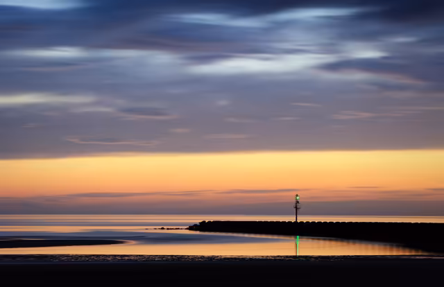 Serene Coastal Sunset With Lighthouse