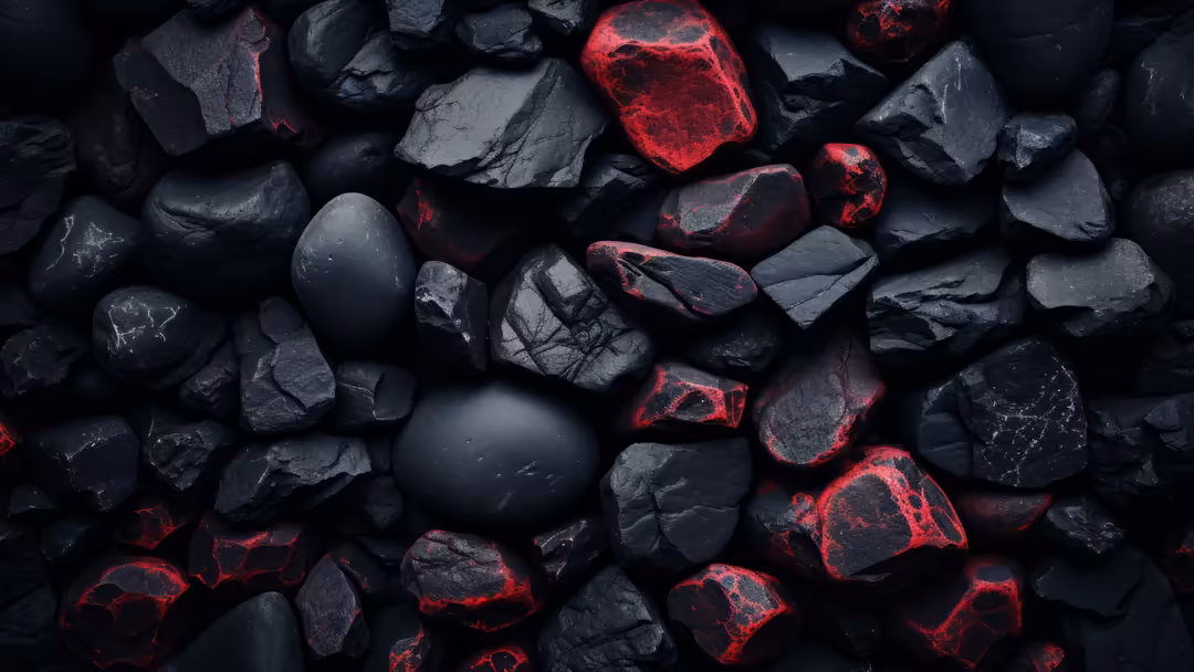 Dark volcanic rocks with glowing red lava cracks and smooth spheres scattered across textured black stone surface