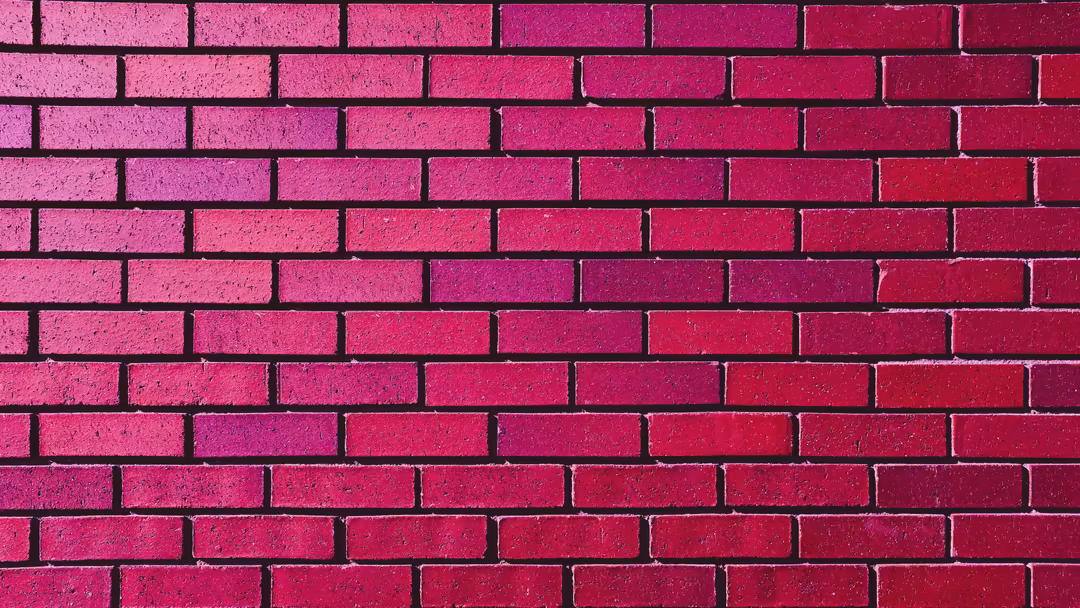 Bright magenta to deep red brick wall with textured surface and dark mortar lines creating geometric pattern