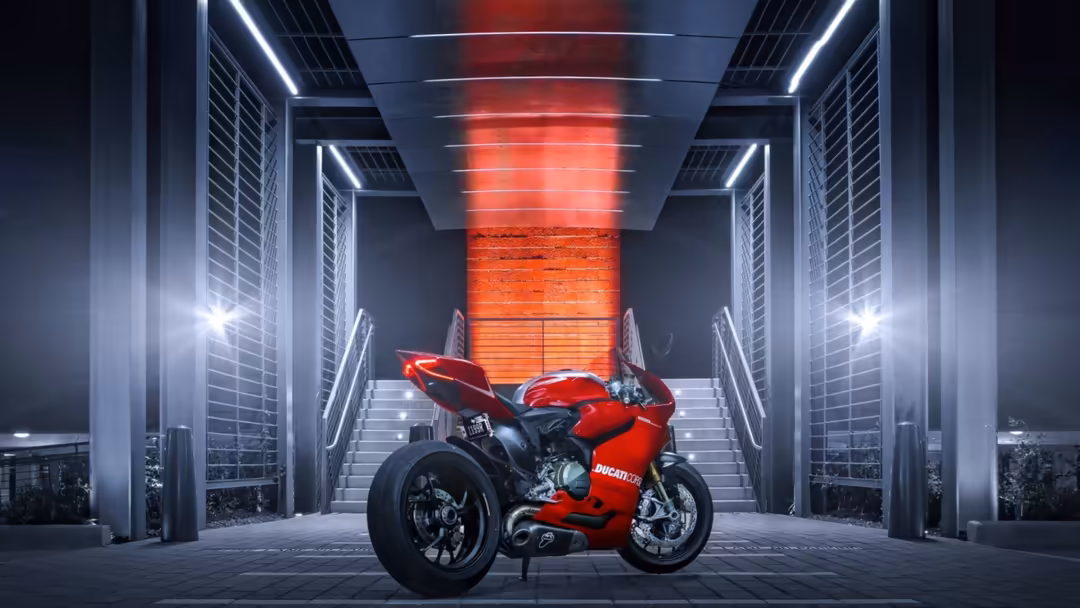 Red motorcycle displayed in a futuristic corridor with white neon lights and red glowing columns, modern architectural settin