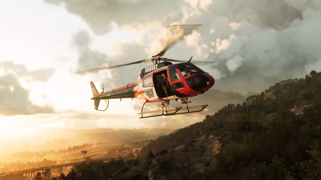 Red and white rescue helicopter flying over mountainous terrain at sunset with forested landscape below