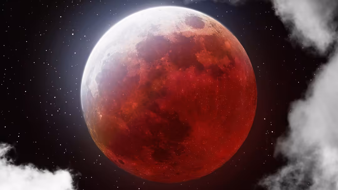 A dramatic red lunar eclipse moon glowing against a starry night sky with white clouds surrounding the cosmic celestial body.