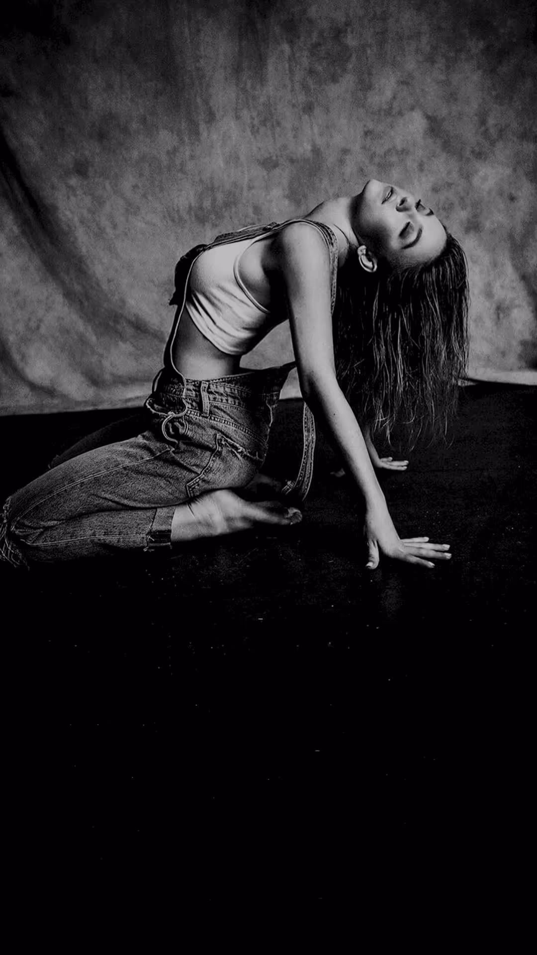 Sydney Sweeney in black and white studio portrait shot, head tilted back with closed eyes, wearing a light crop top and jeans