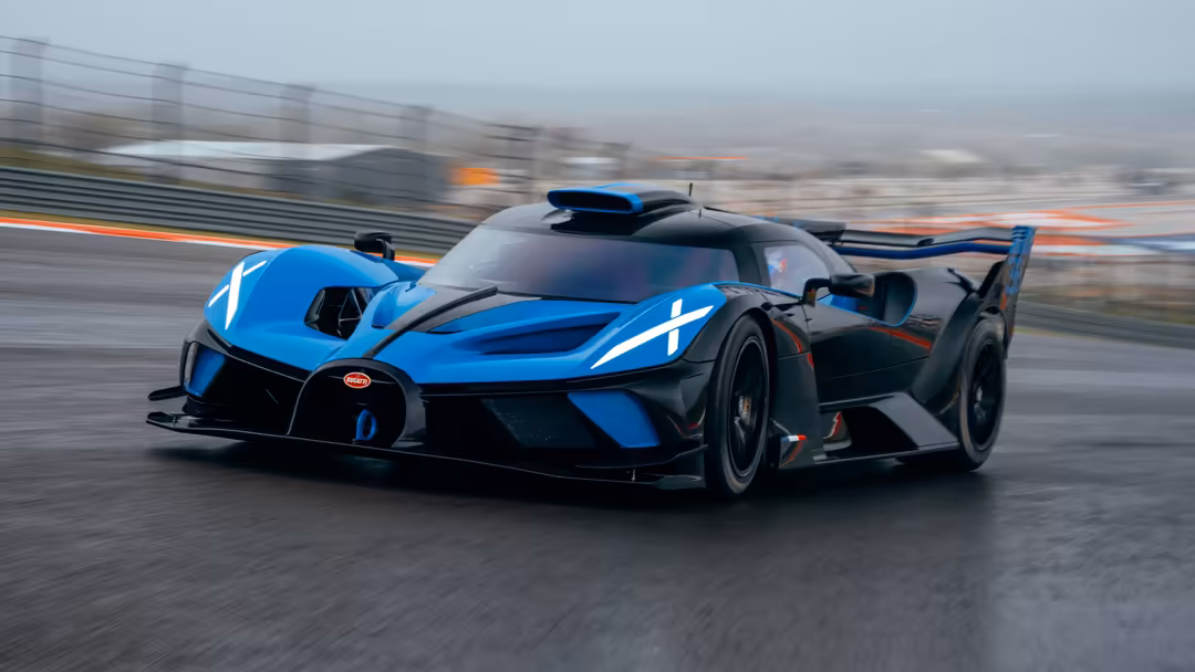 Blue and black Bugatti Bolide hypercar racing on track with motion blur, featuring aerodynamic design and open doors