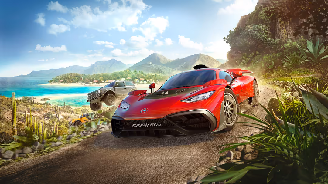 Red Mercedes-AMG Project One supercar on a coastal mountain road with turquoise ocean, tropical vegetation, and mountains in