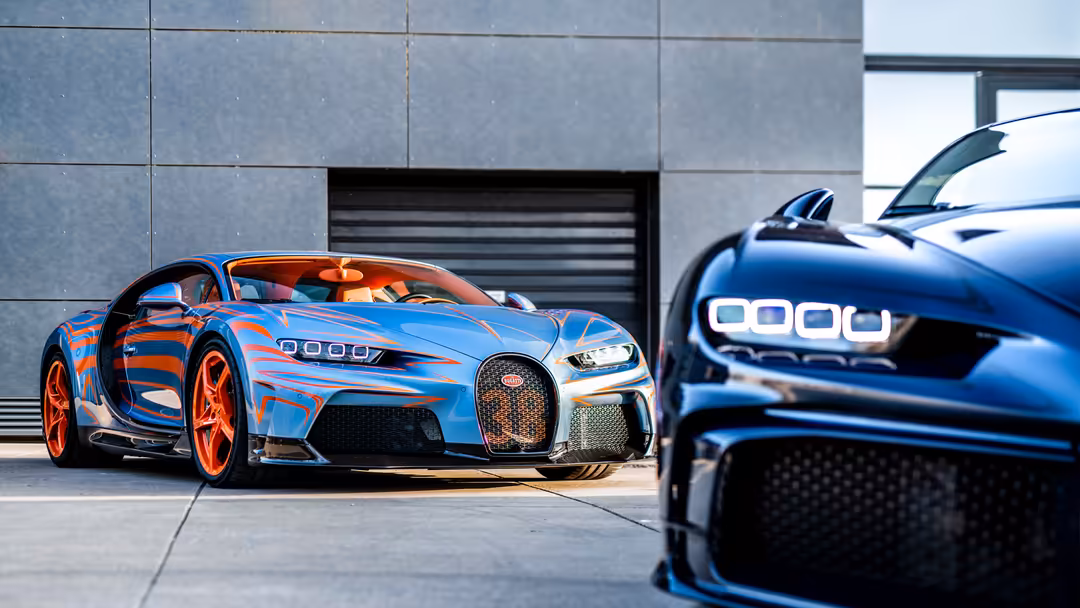 Blue and orange Bugatti Chiron Super Sport with distinctive quad headlights parked in modern garage setting with contemporary