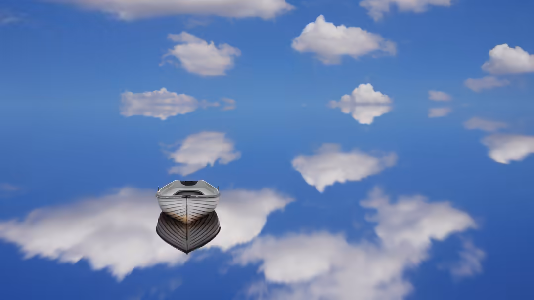 Small white boat floating in a serene blue sky with soft white clouds reflected below, creating a surreal and peaceful dreaml