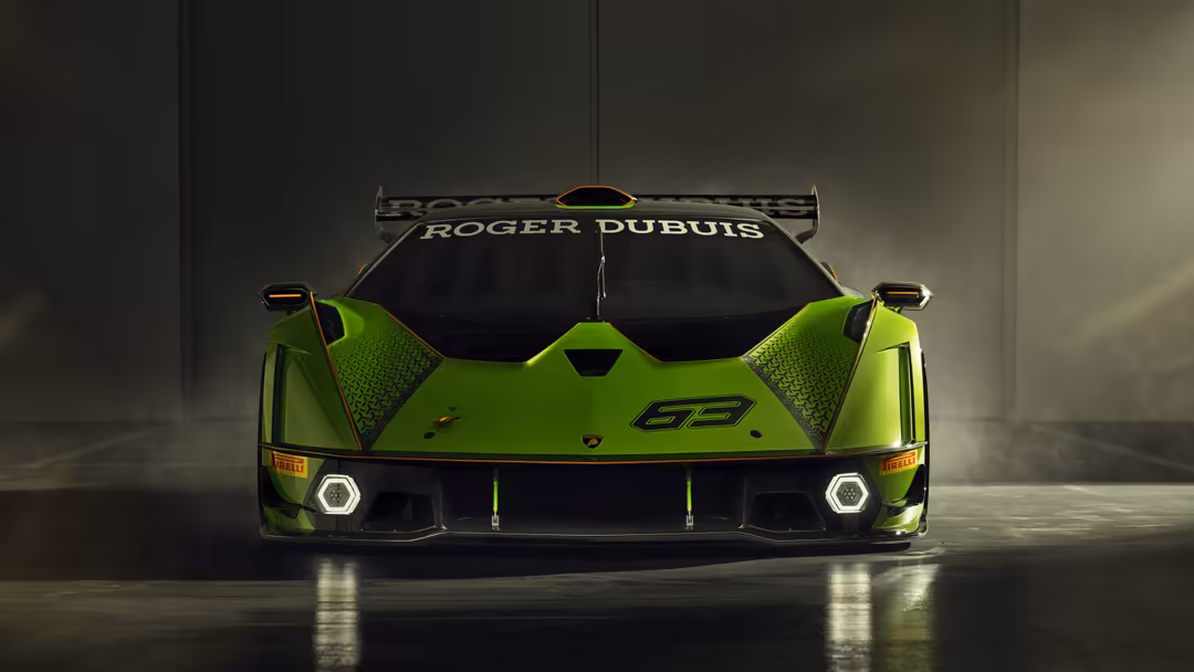 Neon green Lamborghini Essenza SCV12 racing car with aggressive aerodynamics and headlights illuminated in a concrete garage
