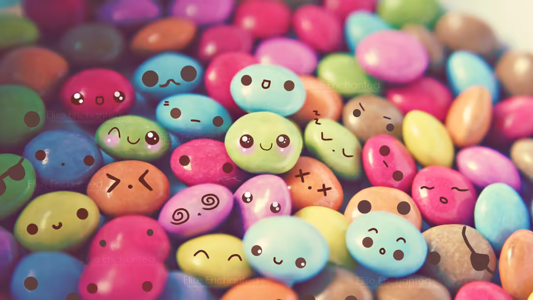 Colorful bean-shaped characters with cheerful hand-drawn faces in pink, yellow, blue, and green tones arranged closely togeth