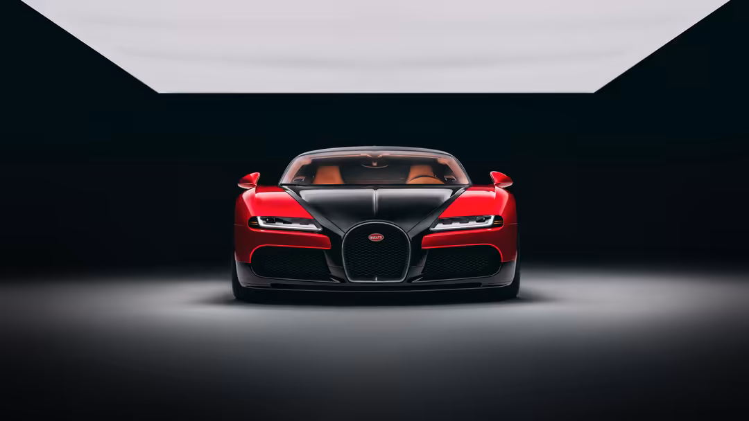 Front view of a striking red Bugatti FKP Hommage supercar in a minimalist dark garage with dramatic lighting
