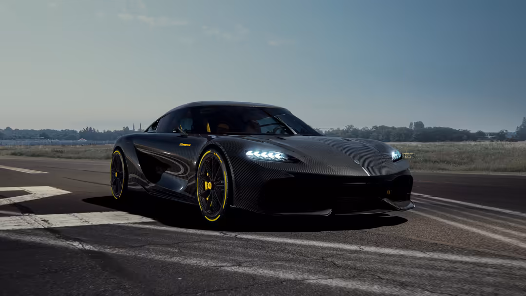 Black carbon fiber Koenigsegg Gemera hypercar with yellow accents parked on an empty airfield runway with clear blue sky.