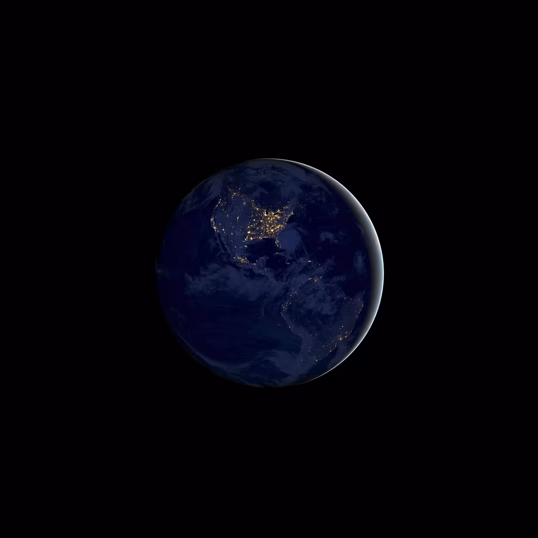 Earth at night showing city lights across North America and Asia against black space background with atmospheric glow